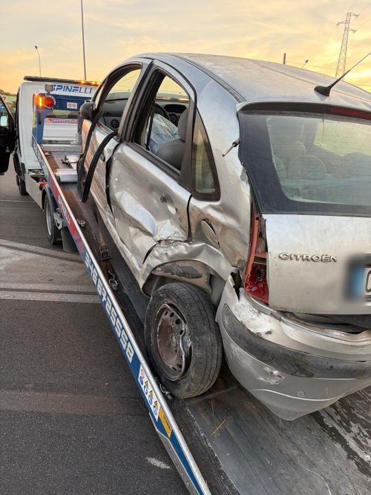 Auto con la fiancata danneggiata, caricata sul carro attrezzi
