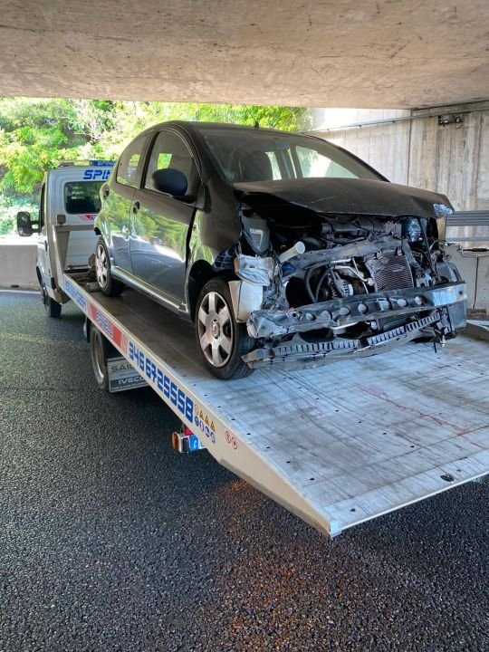 Auto con il frontale distrutto sul pianale del carro attrezzi