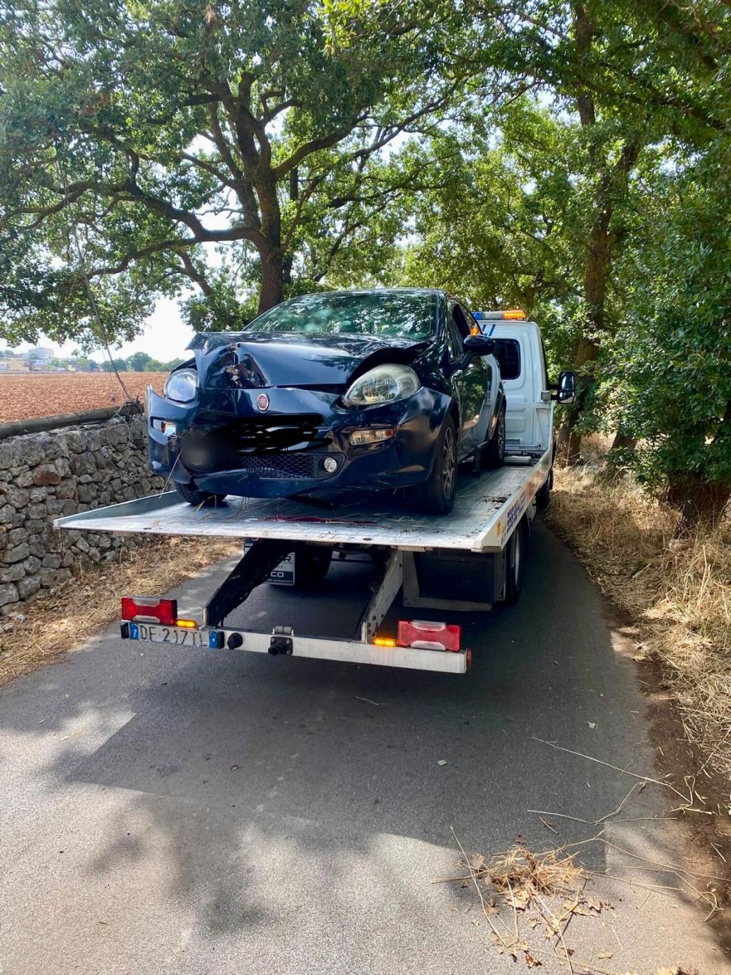Auto finita contro un albero, recuperata e caricata sul carro attrezzi